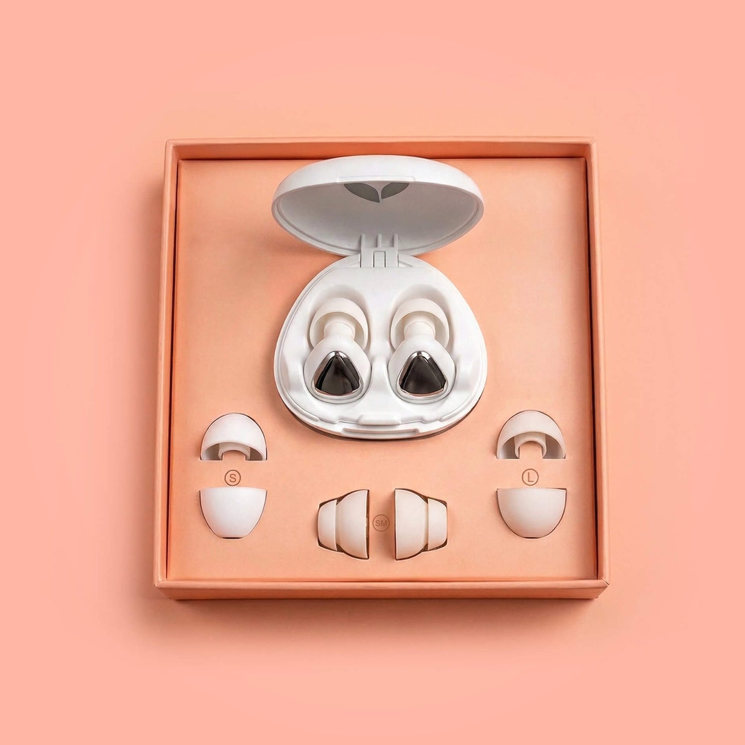 White earplugs in an open peach box on a peach background