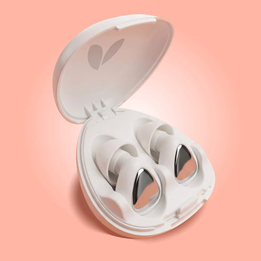 White earplugs in an open case on a peach background